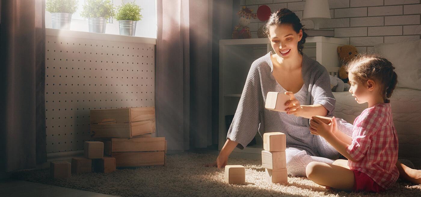 Image of a woman sitting on the floor with her daughter